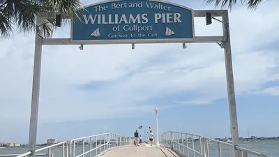 Lit Williams Pier entrance sign at night in Gulfport